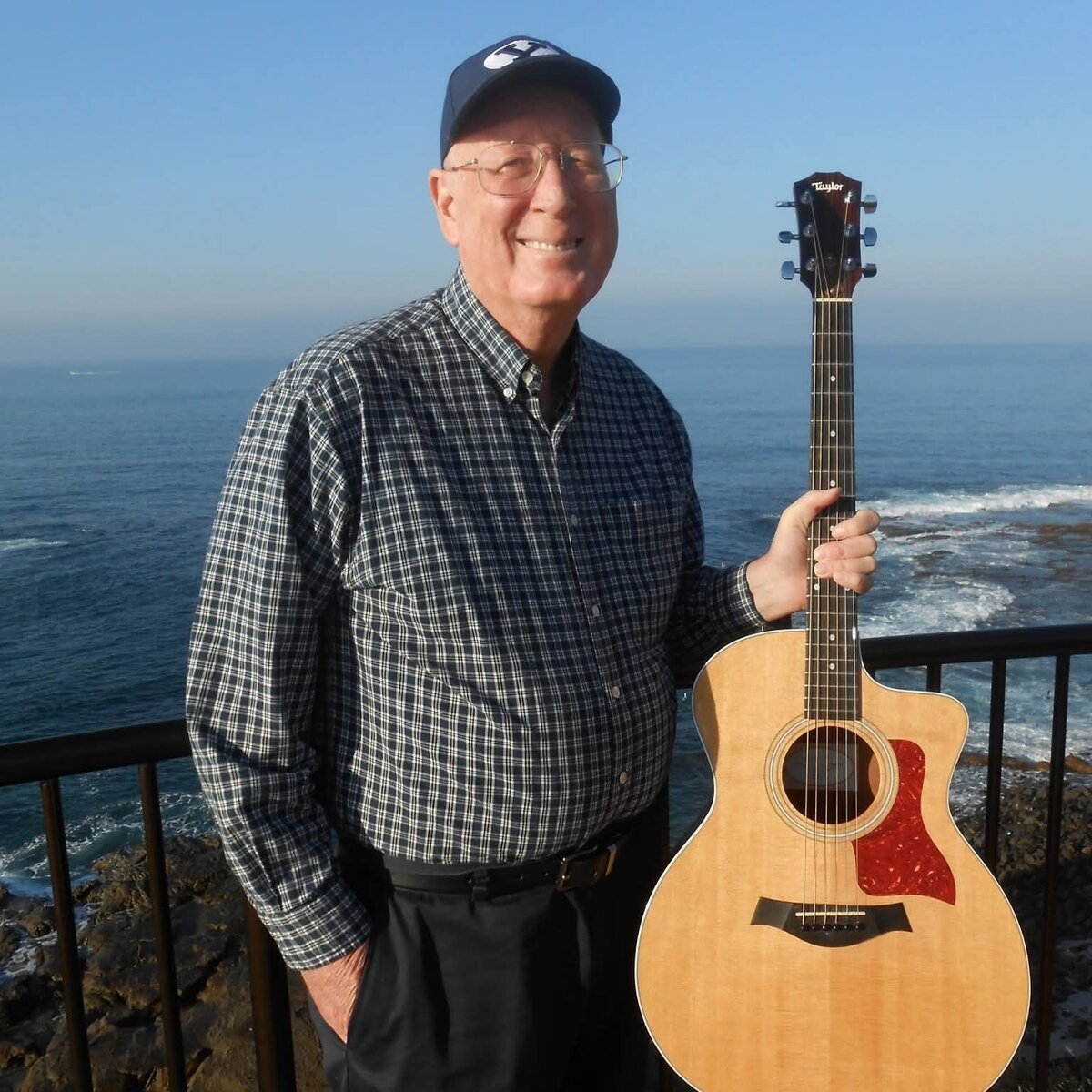 John Sanders with his guitar, by the ocean